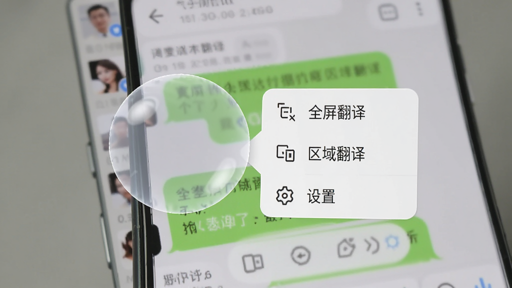 一部安卓手机屏幕边缘有一个半透明的圆形悬浮球,悬浮球旁边展开了一个小型快捷菜单,菜单内包含“全屏翻译”“区域翻译”“设置”等选项,手机背景为社交软件聊天界面,整体风格简洁现代,画质清晰,无多余元素
