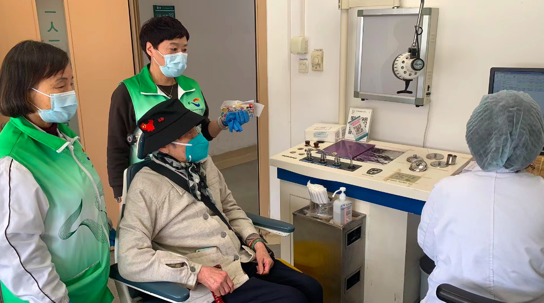 晓棉袄陪诊师帮老人取检查报告并耐心讲解结果的画面