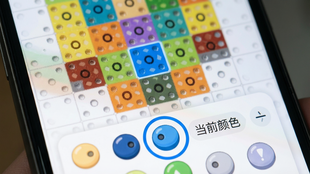 天天来拼豆游戏内色彩提示功能特写,手机屏幕显示一个未完成的拼豆图案,其中一个格子被高亮为蓝色,下方调色盘上蓝色豆子被圈出,旁边有“当前颜色”小标签,整体风格清爽,画质细腻,无多余元素