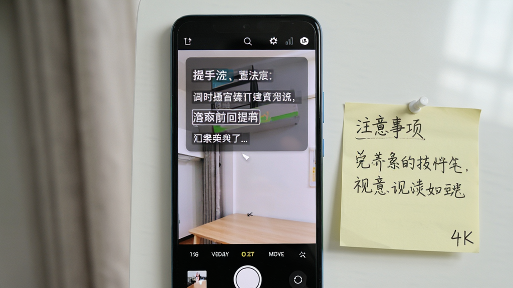 一部安卓手机屏幕显示提词器应用正在运行,屏幕上方是半透明悬浮提词窗口,下方是相机拍摄界面,手机旁边放着一张写有注意事项的便签纸,布局为手机居中、便签纸在旁,排版为使用技巧提示风格,细节包含清晰的悬浮窗文字、便签纸上的手写中文、自然的光线,画质为高清4K,干净,无多余元素