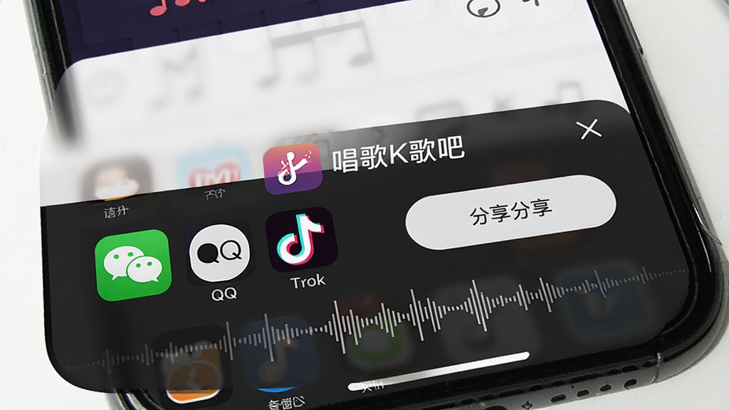 一幅展示唱歌K歌吧作品分享功能的界面示意图,主体为手机屏幕中显示分享面板与社交图标,布局为底部弹窗式,排版直观,风格为现代简约风,细节包含微信、QQ、抖音图标、分享按钮、录音波形,画面中带有