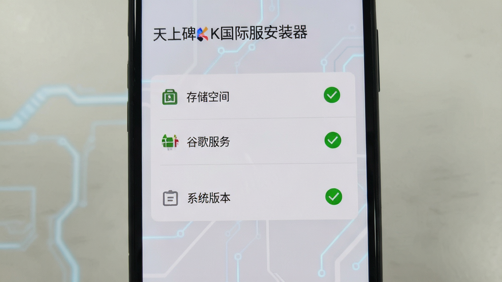 手机屏幕显示“天上碑K国际服安装器”的环境检测界面,界面中有多个勾选项目,如“存储空间”“谷歌服务”“系统版本”,部分项目显示绿色对勾,背景为浅灰色科技风格,画质干净,无多余元素