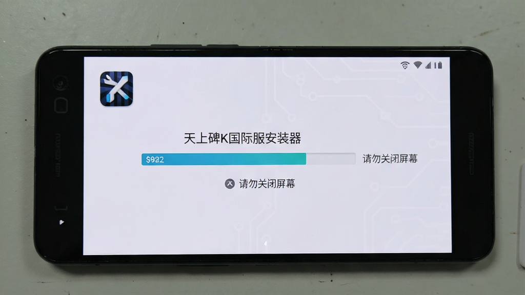 一部安卓手机屏幕显示“天上碑K国际服安装器”的安装进度条,旁边有“请勿关闭屏幕”的提示文字,背景是深色科技风格,画质清晰,无多余元素