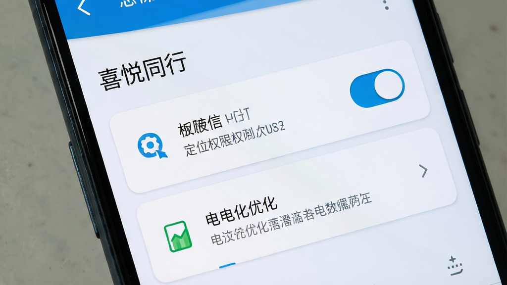 一张手机设置界面示意图,画面为安卓手机屏幕特写,显示“喜悦同行”应用权限管理页面,包含定位权限开关与电池优化选项,界面采用浅色卡片式布局,风格简洁实用,细节包含清晰的开关控件与说明文字,画质干净高清,无多余元素