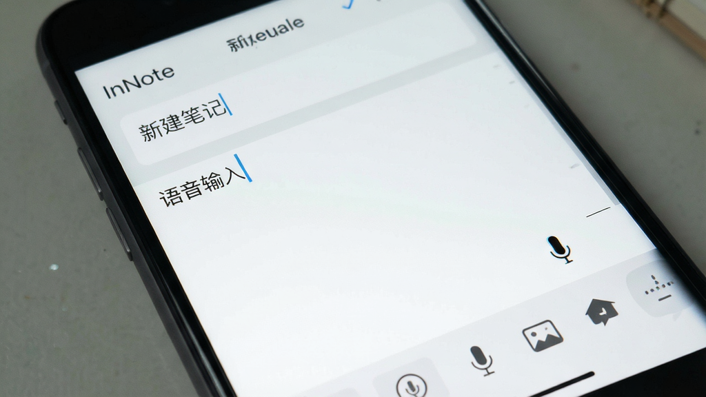 一张手机界面特写,主体为快速新建笔记的编辑页面,布局为上方标题输入框与下方正文编辑区,排版简洁疏朗,风格为清爽浅色系移动应用界面,细节包含光标闪烁效果、底部工具栏的语音与图片图标,画面中出现文字“InNote”“新建笔记”“语音输入”,画质干净清晰无多余元素