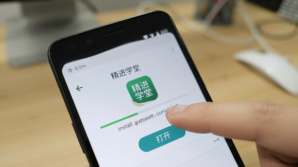 主体为一部安卓手机屏幕显示“精进学堂”应用安装完成界面,旁边有手指点击图标;布局为手机与手指特写占据画面主体,背景为虚化的桌面环境;排版紧凑;风格为写实操作演示风;细节包含安装进度条完成状态、应用图标与“打开”按钮;画质清晰,干净,无多余元素