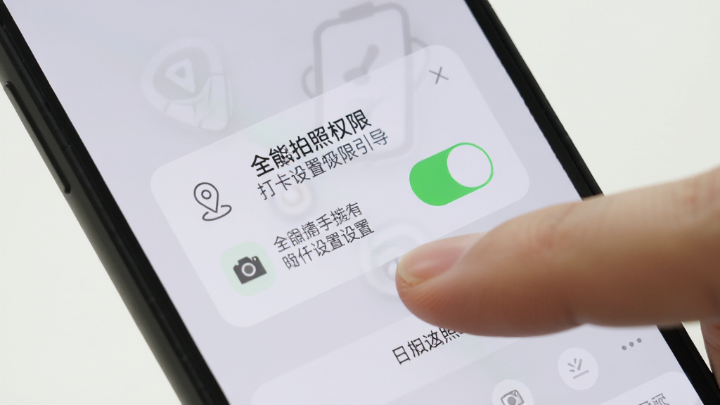 手机屏幕显示水印相机打卡全能拍照的权限设置引导页面,画面上有定位和相机权限的开关图标,背景为简洁的浅色界面,旁边有一只手正在点击屏幕,布局为特写构图,风格写实清晰,细节包括权限弹窗和手指动作,画质干净明亮,无多余元素