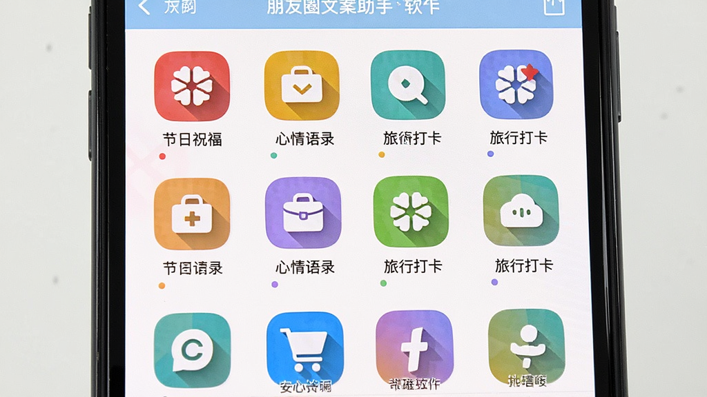 手机屏幕中展示朋友圈文案助手软件的分类文案库页面,画面以网格形式排列多个彩色分类图标,图标下方标注节日祝福、心情语录、旅行打卡等文字,整体布局整齐有序,风格活泼明快,细节清晰,画质干净无杂乱元素