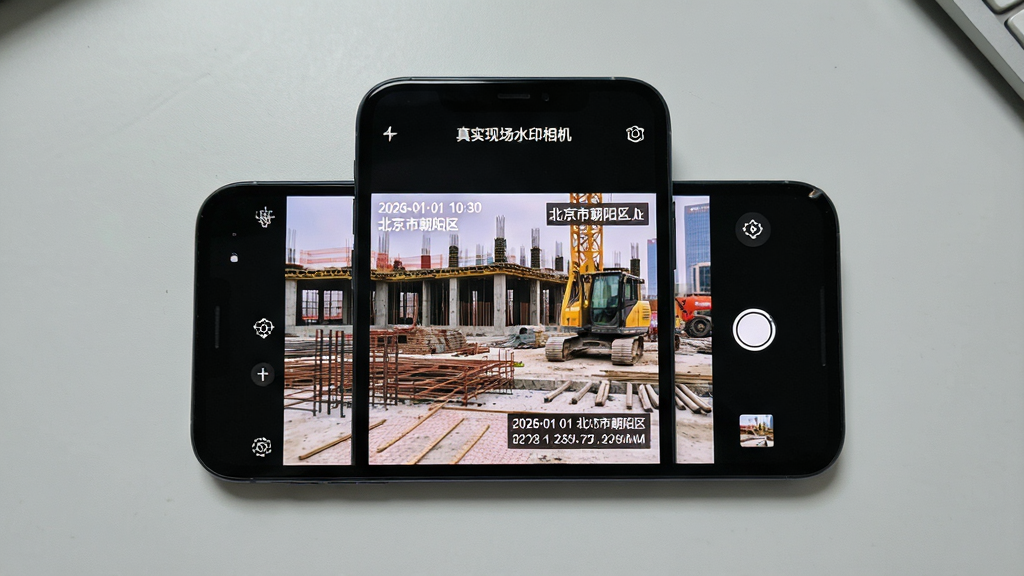 一张手机屏幕展示“真实现场水印相机”拍摄界面的写实图片,画面主体为手机居中放置,屏幕上显示带时间地点水印的施工现场照片,布局简洁,背景为浅灰色桌面,风格为真实产品展示,细节包含水印文字“2026-01-01 10:30 北京市朝阳区”与经纬度信息,画质清晰,干净,无多余元素