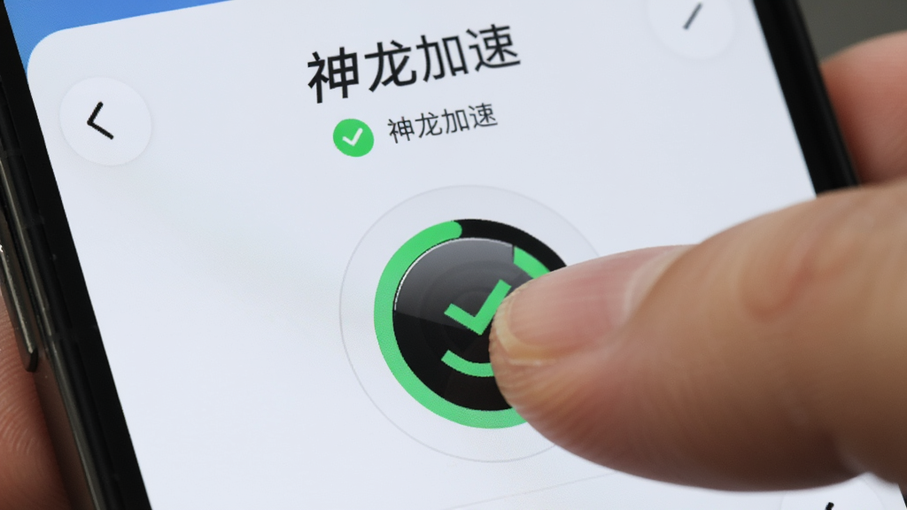 主体为一只手指点击手机屏幕中央圆形按钮的特写,屏幕内显示