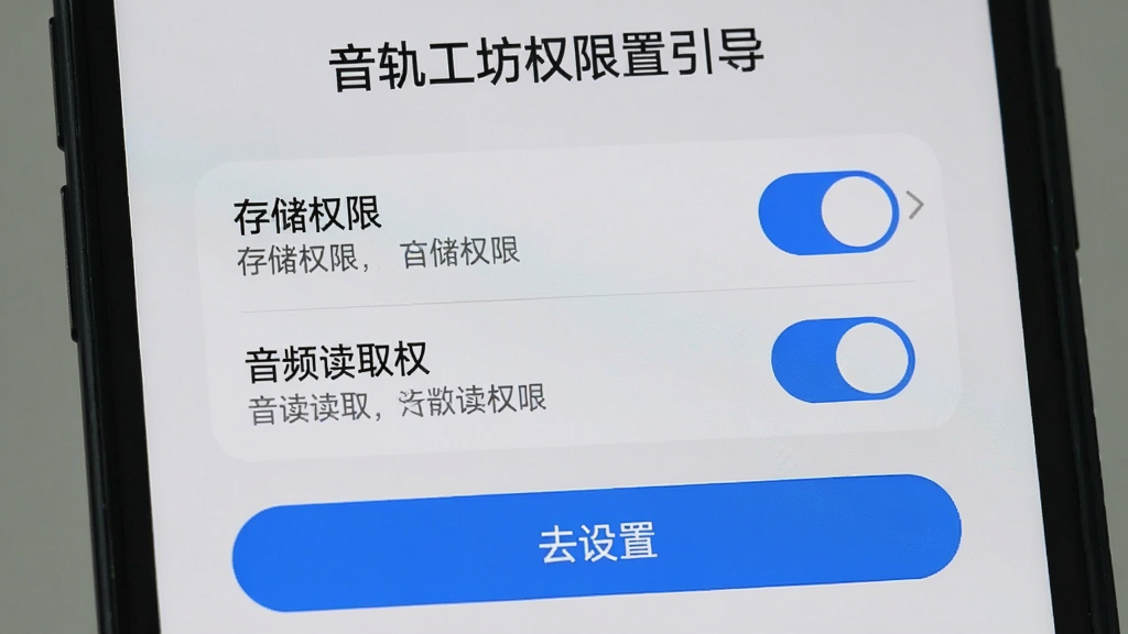 手机屏幕显示音轨工坊权限设置引导页面,界面中央为存储权限和音频读取权限的开关选项,下方有“去设置”按钮,整体采用浅灰色背景搭配蓝色高亮开关,布局清晰,细节上体现权限说明文字简洁明了,画质干净无杂乱