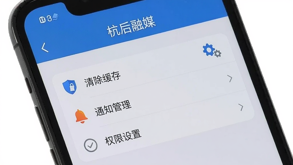 手机屏幕显示“杭后融媒”设置页面,包含“清除缓存”“通知管理”“权限设置”等选项,旁边配有盾牌与齿轮图标,背景为浅灰色,风格简约实用,画面干净清晰,无多余元素