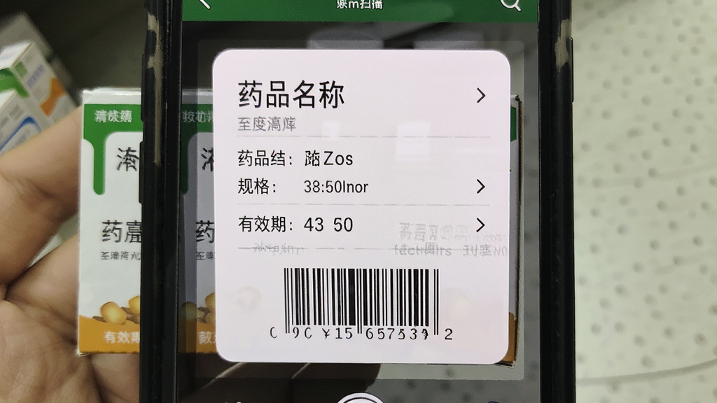 药终端APP的药品扫描界面,手机摄像头对准药品包装上的条形码,屏幕中显示药品详情卡片,包含药品名称、规格和有效期,布局居中,风格写实,细节清晰,画质干净,无多余元素