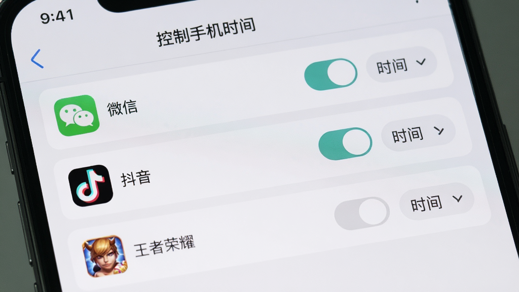 手机屏幕上显示“控制手机时间”应用限制设置界面,列表中有“微信”“抖音”“王者荣耀”等应用,每个应用右侧有开关按钮和时间设置选项,界面采用卡片式设计,背景为浅灰白色,整体风格清爽,画质高清,无多余元素