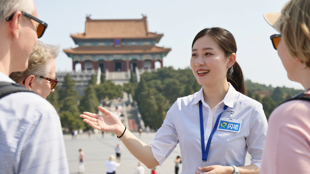 一位亲切的地陪导游正在向游客讲解景点,导游佩戴