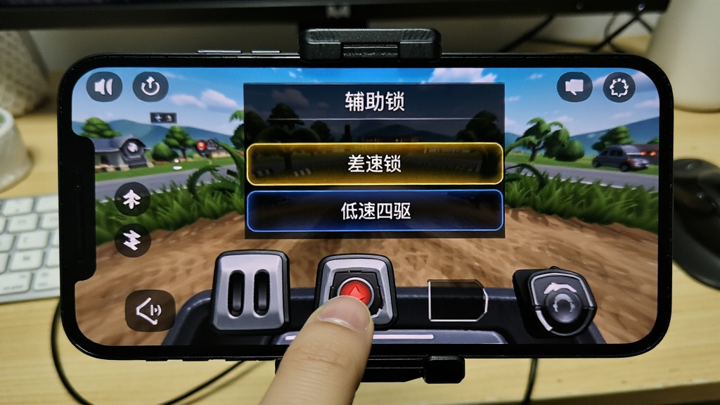 一张手机横屏游戏实拍照片,画面中显示游戏的中文辅助菜单界面,高亮显示着“差速锁”和“低速四驱”选项。手机被固定在车载支架上,背景是室内的书桌。照片构图清晰,重点展示触屏操作下,玩家手指按住屏幕上的虚拟油门按钮,画面细节丰富,光照明亮,画质干净,无多余元素。