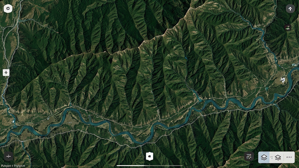 高清地图导航全景软件运行中的卫星地图界面,主体为高清显示的绿色山脉与河流,布局为全屏地图展示,右下角有图层切换按钮,风格为真实卫星摄影风格,细节展现山体阴影与水流纹理,画质超清干净,无多余元素