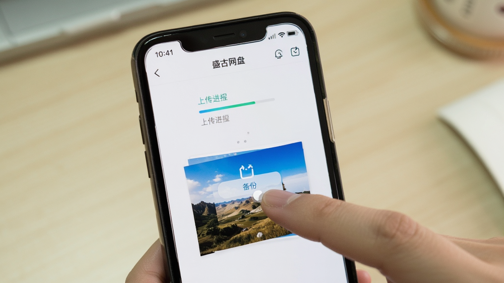 用户使用盛大网盘手机端上传照片,手指点击“备份”按钮,屏幕上方显示上传进度,界面简洁明快,背景为浅色桌面,画面真实自然,画质清晰,无多余元素