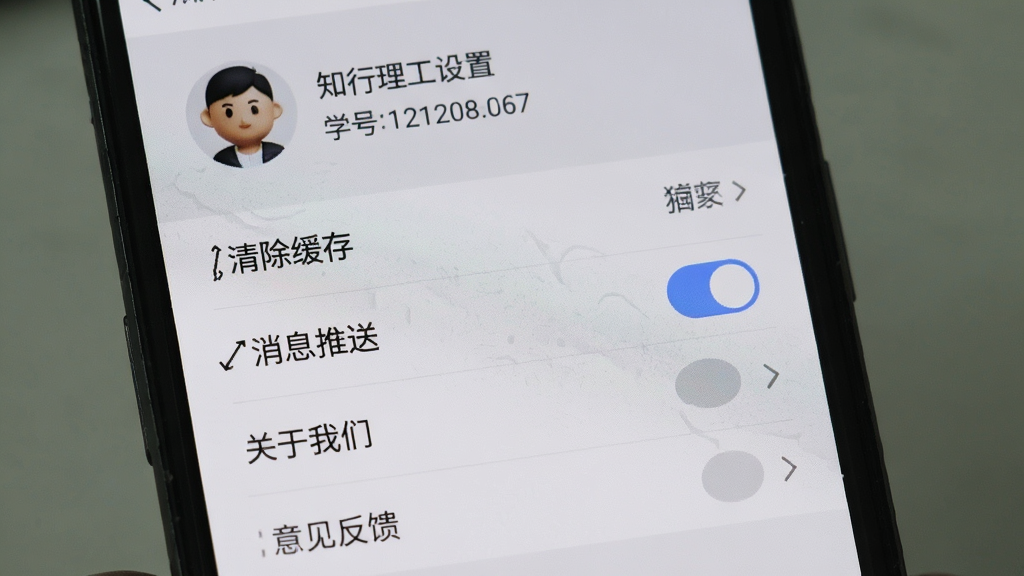 手机屏幕显示知行理工设置页面,列表包含清除缓存、消息推送开关、关于我们、意见反馈等选项,顶部显示用户头像和学号信息,整体风格浅灰质感,画质干净,无多余元素