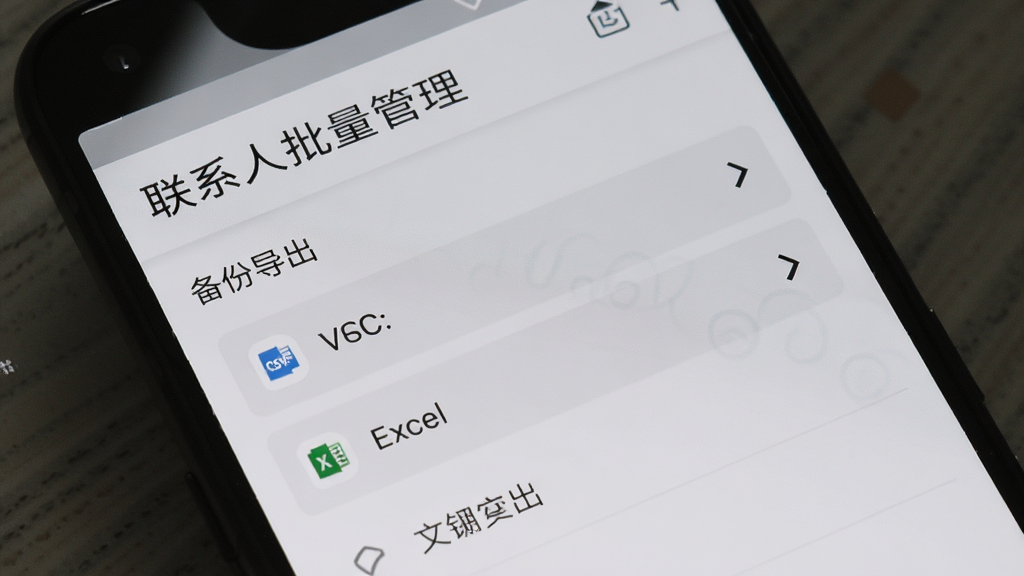 一部安卓手机屏幕显示“联系人批量管理”的备份导出界面,文件格式选项包括VCF、CSV、Excel,背景为浅灰色,风格简约,细节清晰,画质干净,无多余元素