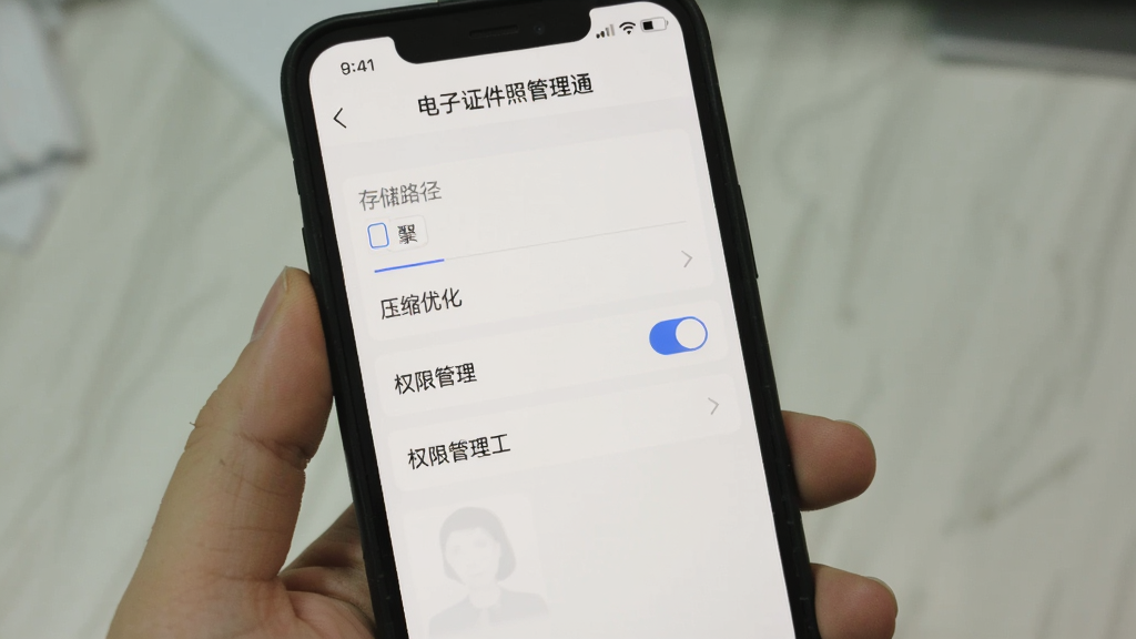 手机屏幕显示“电子证件照管理通”设置页面,包含存储路径选择、压缩优化开关、权限管理入口,界面为浅色主题,文字清晰,画质干净