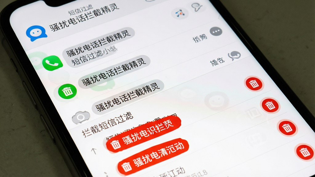 手机屏幕显示骚扰电话拦截精灵的短信拦截界面,界面分为上下两部分,上半部分是正常短信列表,下半部分是拦截短信列表,拦截短信被标记为红色并带有垃圾桶图标,屏幕上方有骚扰电话拦截精灵的logo和“短信过滤”字样,背景为白色简洁风格,画质清晰,干净无多余元素