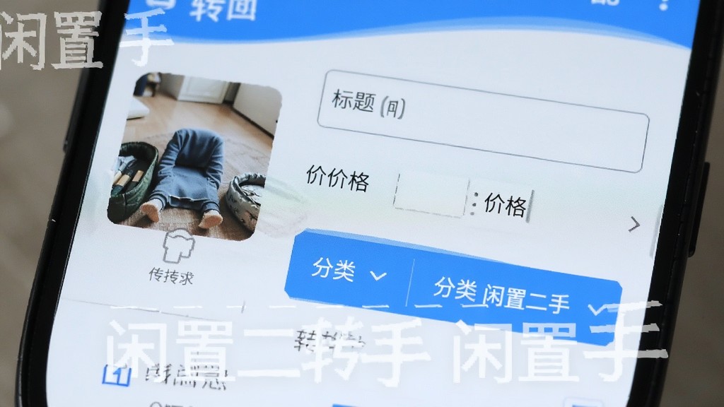 一部安卓手机屏幕特写,界面显示发布闲置物品的表单,包含图片上传区域、标题输入框、价格填写栏和分类选择按钮,界面配色以蓝白为主,风格清新简洁,画质清晰,干净无杂乱元素,图片中带有“闲置二手转手”文字标识