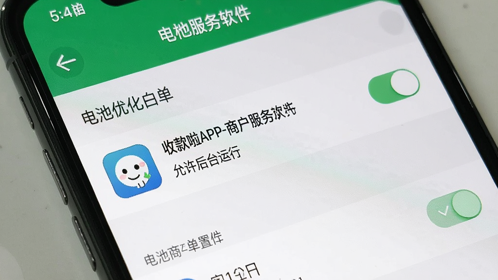 一张展示收款啦APP-商户服务软件在手机后台运行设置的界面截图。主体是手机屏幕显示电池优化白名单列表,收款啦APP-商户服务软件图标旁显示“允许后台运行”。布局为手机正面特写。排版清晰展示设置路径。风格为手机系统UI写实风,细节包含设置菜单文字和开关按钮。画质清晰,画面干净,无多余元素。