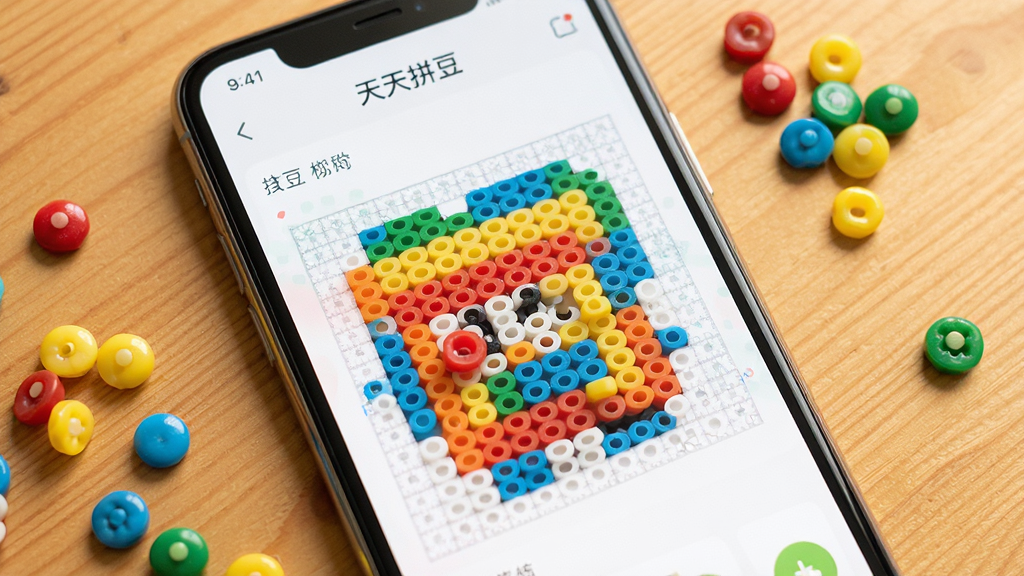 一张手机屏幕展示天天拼豆软件界面的图片,画面中央是彩色拼豆图案正在被一颗颗填充到网格模板上,周围散落着红黄蓝绿各色圆形豆子,背景是温馨的木纹桌面,整体风格清新明快,细节丰富,画质清晰干净,无多余元素