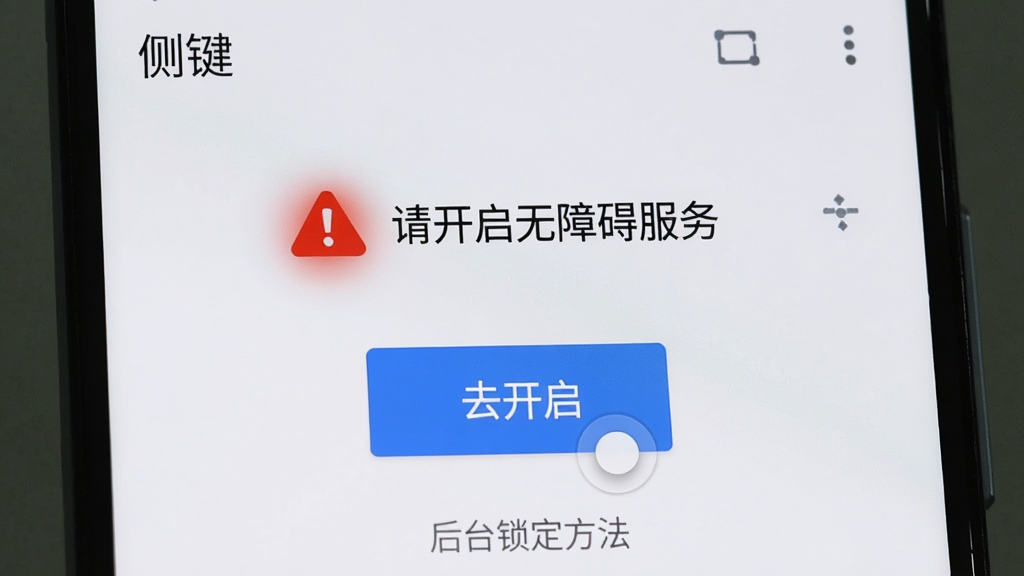 一部安卓手机屏幕显示“侧键”应用的设置向导页面,页面顶部有红色警告图标和文字“请开启无障碍服务”,下方有蓝色按钮“去开启”,底部有灰色小字提示“后台锁定方法”,布局为手机界面截图风格,细节包括按钮的按压状态和警告图标的光晕,画质清晰干净,画面中带有“侧键”应用名称