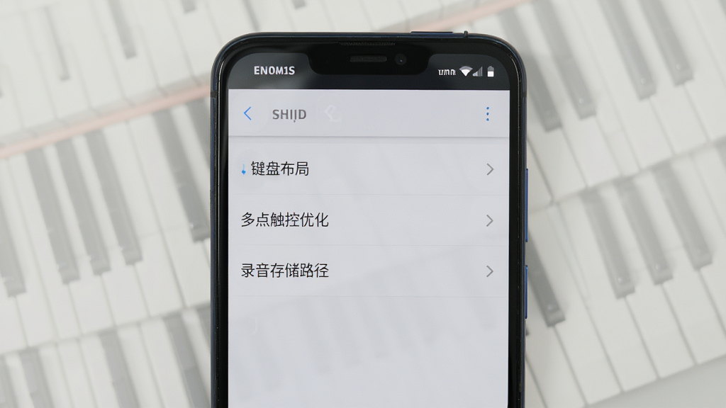 一部安卓手机显示ym电子钢琴的设置页面,页面中包含“键盘布局”“多点触控优化”“录音存储路径”等选项,背景为浅灰色,界面风格干净素雅,画质清晰,无多余装饰元素