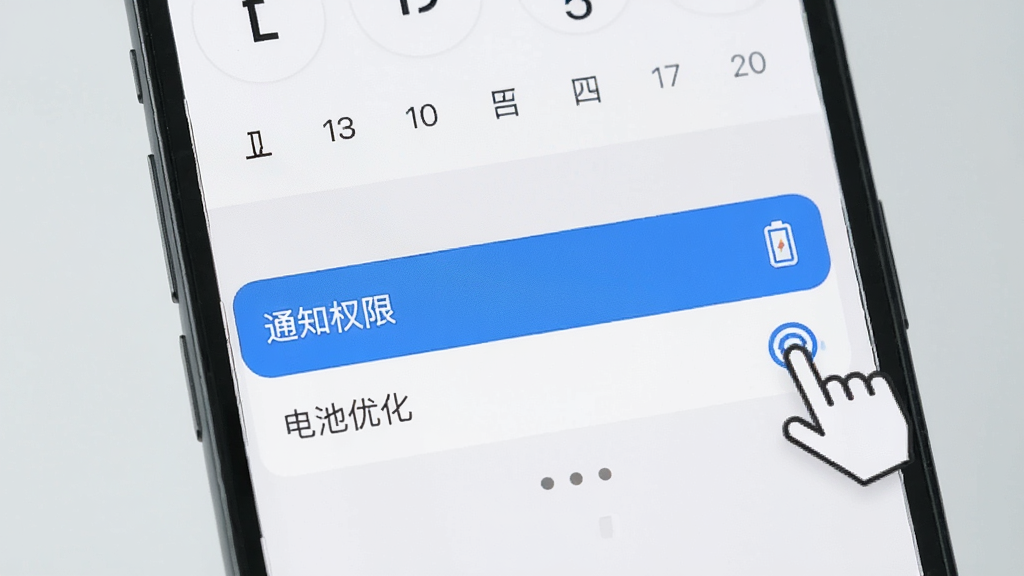 一部手机展示一叶日历的设置界面,画面中高亮显示“通知权限”和“电池优化”选项,旁边有手指点击的图标,背景为简洁的浅灰色,排版清晰,风格直观,细节明确,画质干净,无多余元素